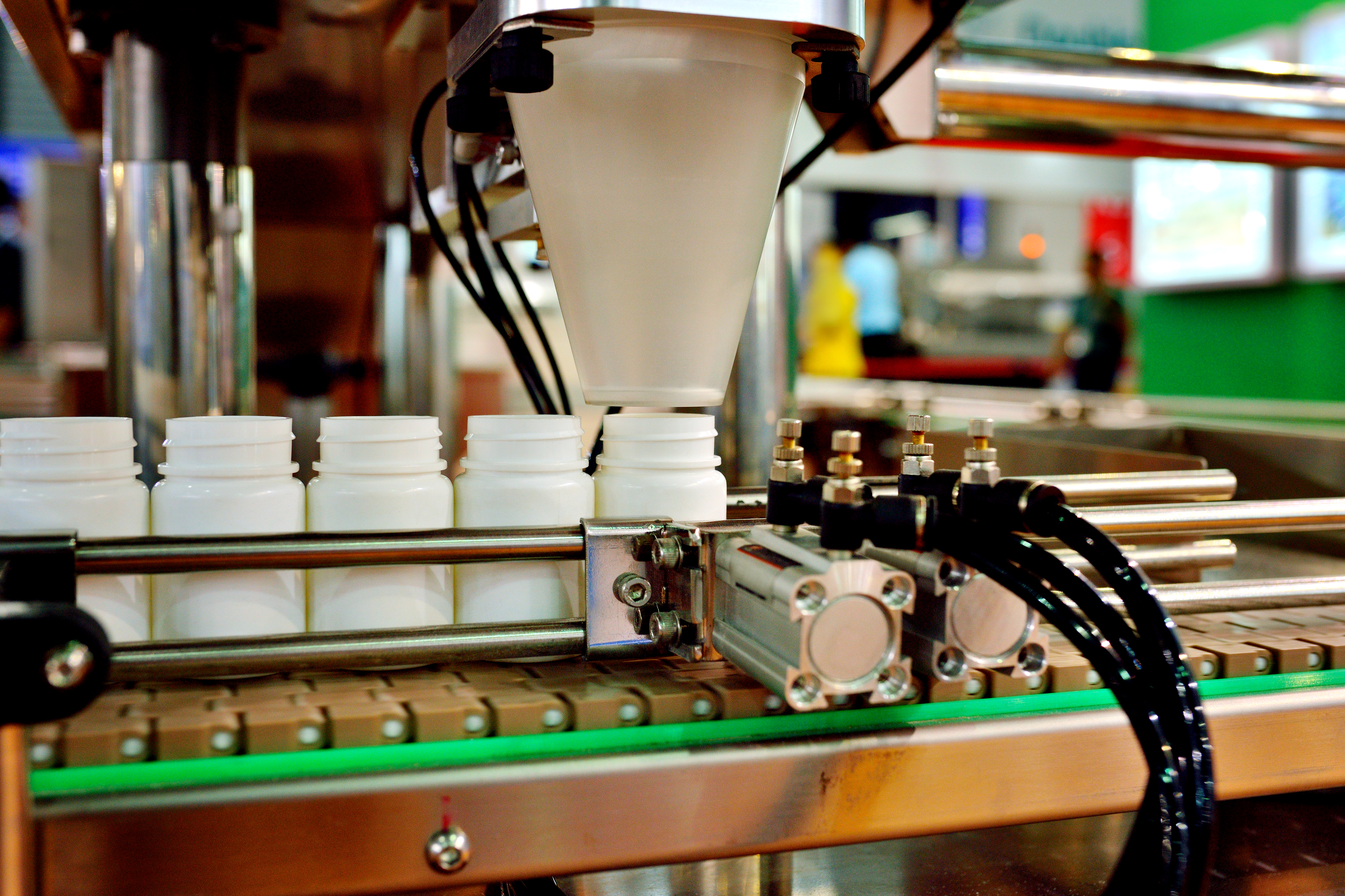 Machinery putting supplements into plastic white bottles