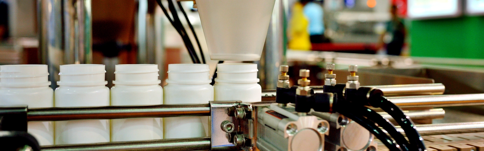 Machinery putting supplements into plastic white bottles Machinery putting supplements into plastic white bottles