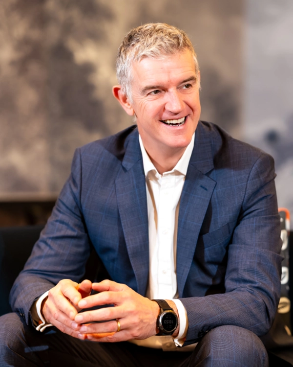 Education & Training Partner Mark Jeynes sitting of sofa laughing Education & Training Partner Mark Jeynes sitting of sofa laughing