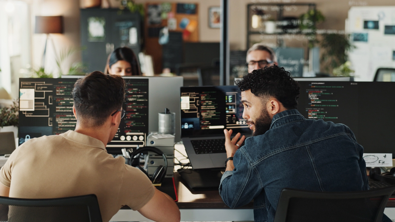 Two men sitting in front of computers creating software Two men sitting in front of computers creating software