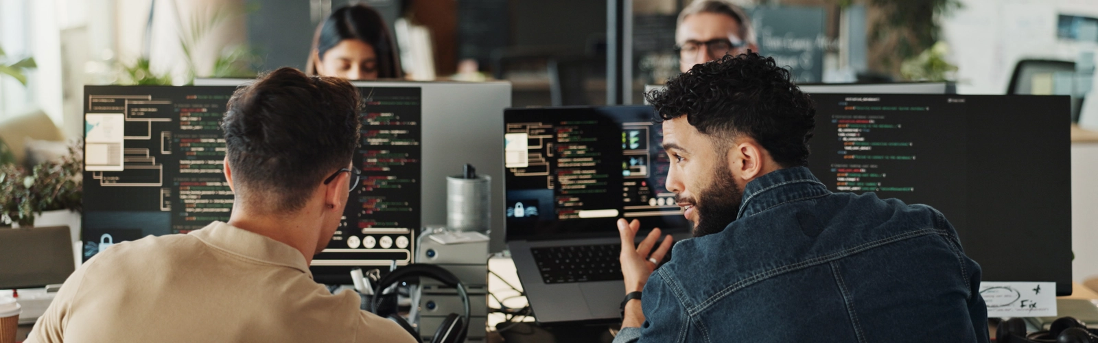 Two men sitting in front of computers creating software Two men sitting in front of computers creating software