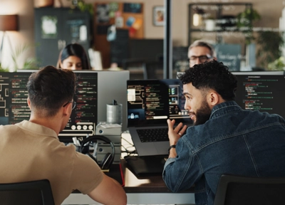 Two men sitting in front of computers creating software Two men sitting in front of computers creating software