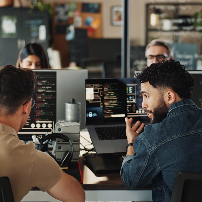 Two men sitting in front of computers creating software Two men sitting in front of computers creating software