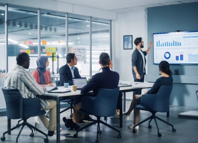 People sitting around room and talking about data People sitting around room and talking about data