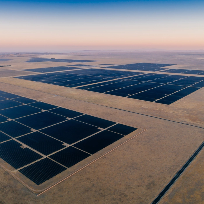 Massive solar farm stretching across desert landscape beneath soft pastel sunrise skies. Massive solar farm stretching across desert landscape beneath soft pastel sunrise skies.